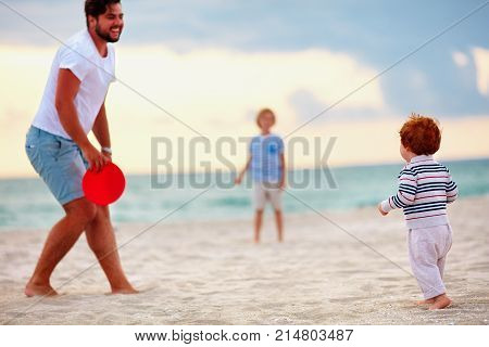 Happy Father With Kids, Family Playing Flying Disc Golf On Evening Beach