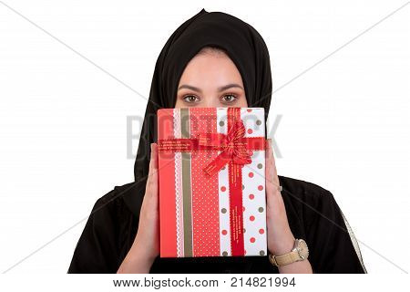 Happy young muslim woman with gift box isolated over white background.