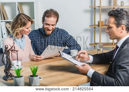 Smiling Couple Reading Contract