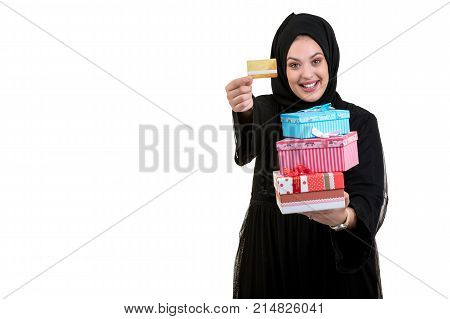 Happy young muslim woman with shopping bag and gift boxes isolated over white background.