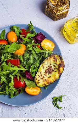 Raw arugula with vegetables and citrus. Selective focus.