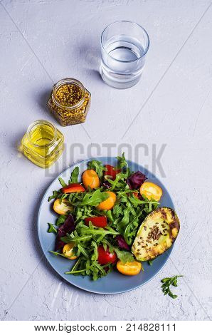 Raw arugula with vegetables and citrus. Selective focus.