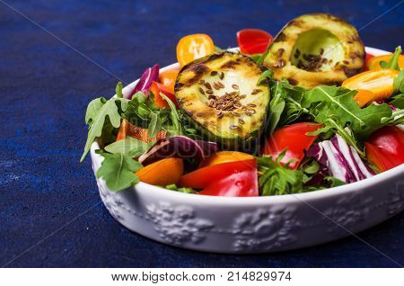 Raw arugula with vegetables and citrus. Selective focus.