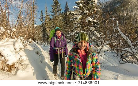Two Happy Women Traveler With Backpacks Walking In Winter Forest