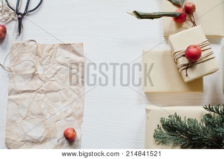 Sheet of paper with rustic wrapped boxes on white table