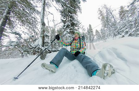 Happy Tourist Girl With A Backpack Sits In A Winter Mauntains Trees