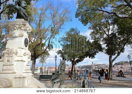LISBON, PORTUGAL - NOVEMBER 4, 2017: Sao Pedro de Alcantara viewpoint (Miradorou) in Bairro Alto neighborhood with a monument to Eduardo Coelho in the foreground