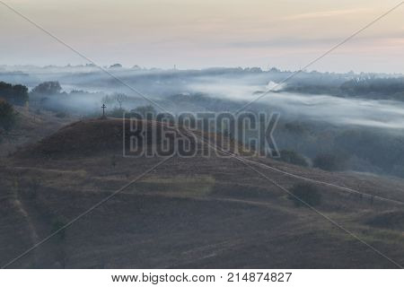 Morning autumn landscape: fog over hills and forest. View from above. Village Opishnya Poltava region Ukraine