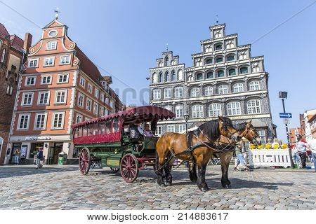 LUNEBURG, GERMANY - MAY 28, 2016: Horse-drawn coach on the historic square in Luneburg