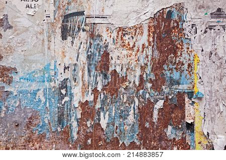 grunge ripped poster background - texture of torn advertisement on an old rusty billboard panel