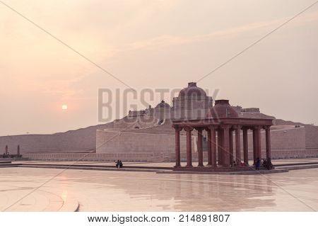 Courtyard of Ambedkar park shot against the setting sun. A multi pillar canopy and the main dome of the Ambedkar Stupa is clearly visible