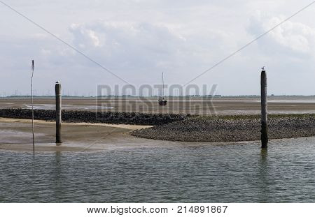 Image Shows A Stranded Sailboat At Low Tide In The Sand