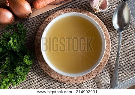 Chicken Bone Broth With Vegetables In The Background, Top View