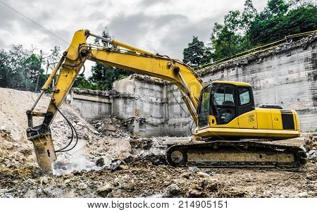 Demolition machine crushing debris of old estructure