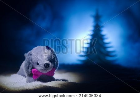 Toy Dog - A Symbol Of The New Year Under The Snow Against The Background Of Fir Branches. Toy's Dog 