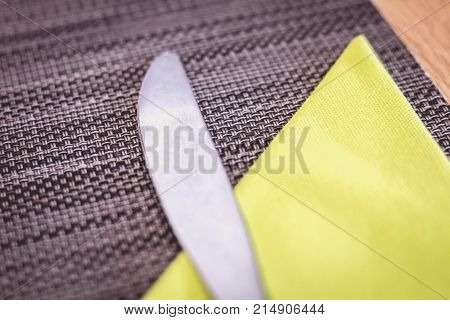 Knife Lying On A Placemat With A Yellow Paper Towel