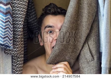 a young man hiding in the closet women's clothing