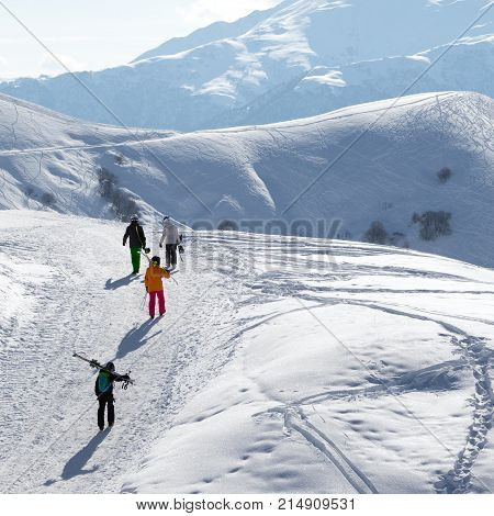 Skiers And Snowboarders On Snow Road At Sun Winter Morning