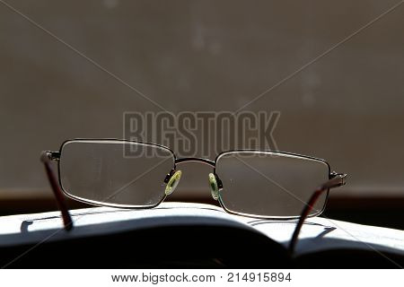 glasses with dioptres for reading standing on an open book