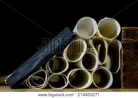 Old Rolls And Plans In Folded Paper Rolls. Old Book And Case. Documents On An Old Wooden Table.
