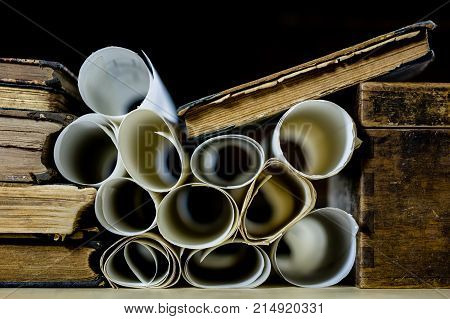 Old Rolls And Plans In Folded Paper Rolls. Old Book And Case. Documents On An Old Wooden Table.