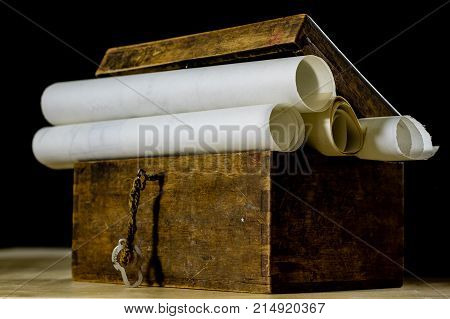 Old Rolls And Plans In Folded Paper Rolls. Old Book And Case. Documents On An Old Wooden Table.