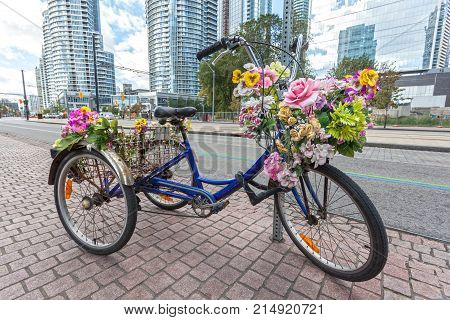 Classic tricycle or trike with flowers in the city