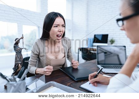The couple went to a lawyer to conclude an agreement on the divorce. They quarrel and argue with each other. Lawyer prepares documents.