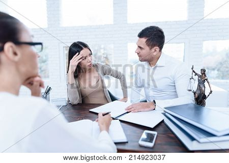 The couple went to a lawyer to conclude an agreement on the divorce. They quarrel and argue with each other. Lawyer prepares documents.