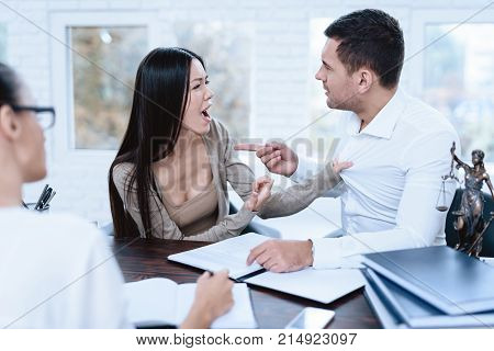 The couple went to a lawyer to conclude an agreement on the divorce. They quarrel and argue with each other. Lawyer prepares documents.