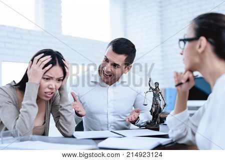 The couple went to a lawyer to conclude an agreement on the divorce. They quarrel and argue with each other. Lawyer prepares documents.