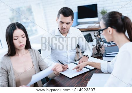 The couple went to a lawyer to conclude an agreement on the divorce. They quarrel and argue with each other. Lawyer prepares documents.