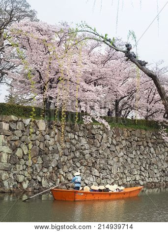 Himeji, Japan - April 10, 2017 : Tourist cruise boat on a canals around Himeji Castle. On the day of cherry blossoms in full bloom. Himeji-Jo Castle is famous travel spot in kansai area in Japan.