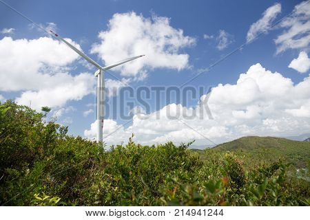 wind turbine system to produce green electricity for renewable energy at power station Lamma island Hong Kong with mountain and blue sky background and copy space
