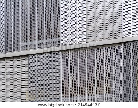 full frame detail of a house facade cased with metallic perforated plates