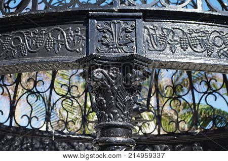 Black steel gazebo pillar intricately cast with engraving around the edge