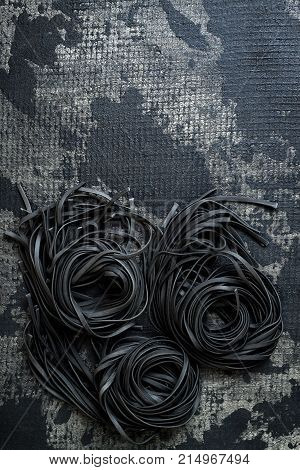 Detox charcoal or squid ink fettuccine on black background