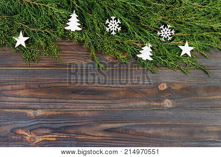 Black wooden christmas background. twigs of thuja. Original fresh floral design for xmas card. empty space for holiday greetings.