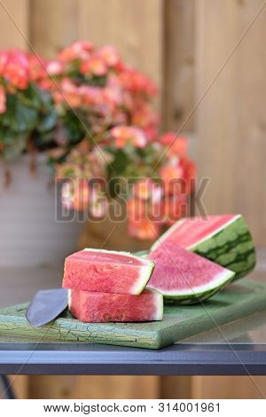 Fresh Sliced Watermelon On A Vintage Cutting Board With An Oustide Background.
