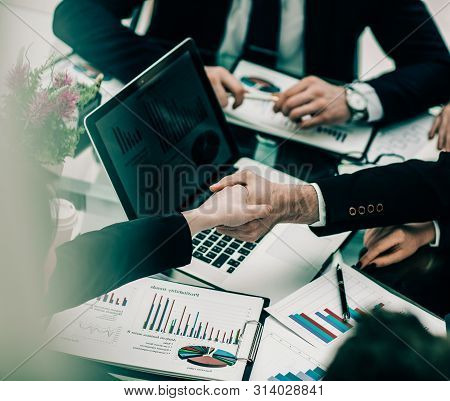 Handshake Of Business Partners On The Background Of The Financia