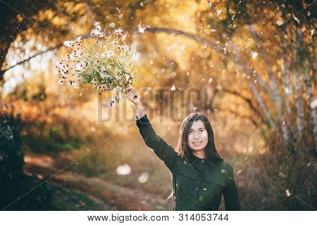 Dreamy Beautiful Girl With Thistle Flowers On Bokeh Background With Yellow Leaves. White Fluff In Go