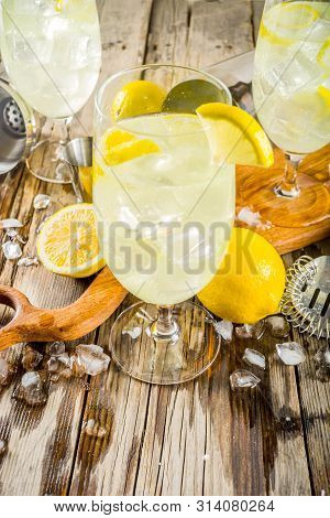 Trendy Summer Cold Drink. St Germain French Spritz Cocktail With Lemon Slices, Old Rustic Wooden Bac