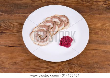 Sliced Baked Roll Made Of Pork Belly And Beetroot Horseradish Sauce On Dish On The Wooden Rustic Tab