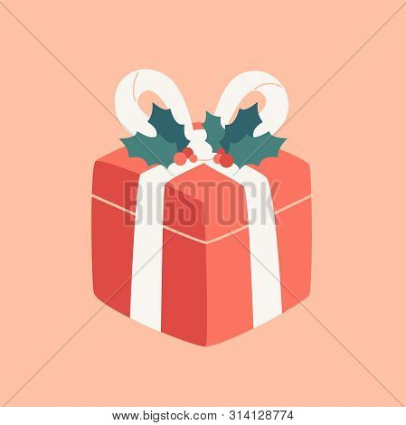 Cartoon Red Gift Decorated With White Ribbon And Holly Leaves. Festive Surprise Present For Merry Ch