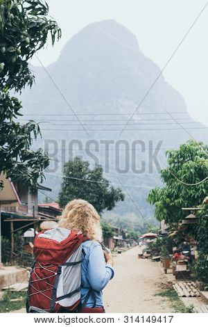 Young Caucasian Blonde Woman With Backpack Standing On The Central Street Of Muang Ngoi Village, Lao