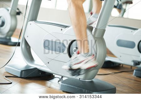 Detail of a man biking in a gym