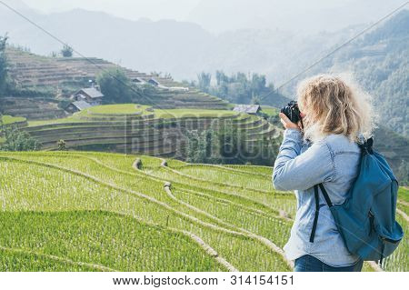 Young Caucasian Blonde Woman In Denim Shirt Taking Pictures Of Sapa Rice Terraces At Sunset In Lao C