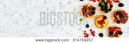 Tartlets With Different Berries On White Background. Top View. Banner.