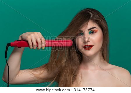 Portrait Of Beautiful Young Woman With Bright Color Make-up Doing Hair Style Herself With A Purple S