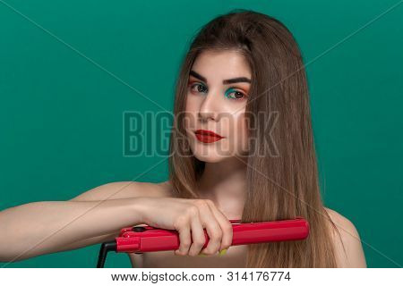 Portrait Of Beautiful Young Woman With Bright Color Make-up Doing Hair Style Herself With A Purple S